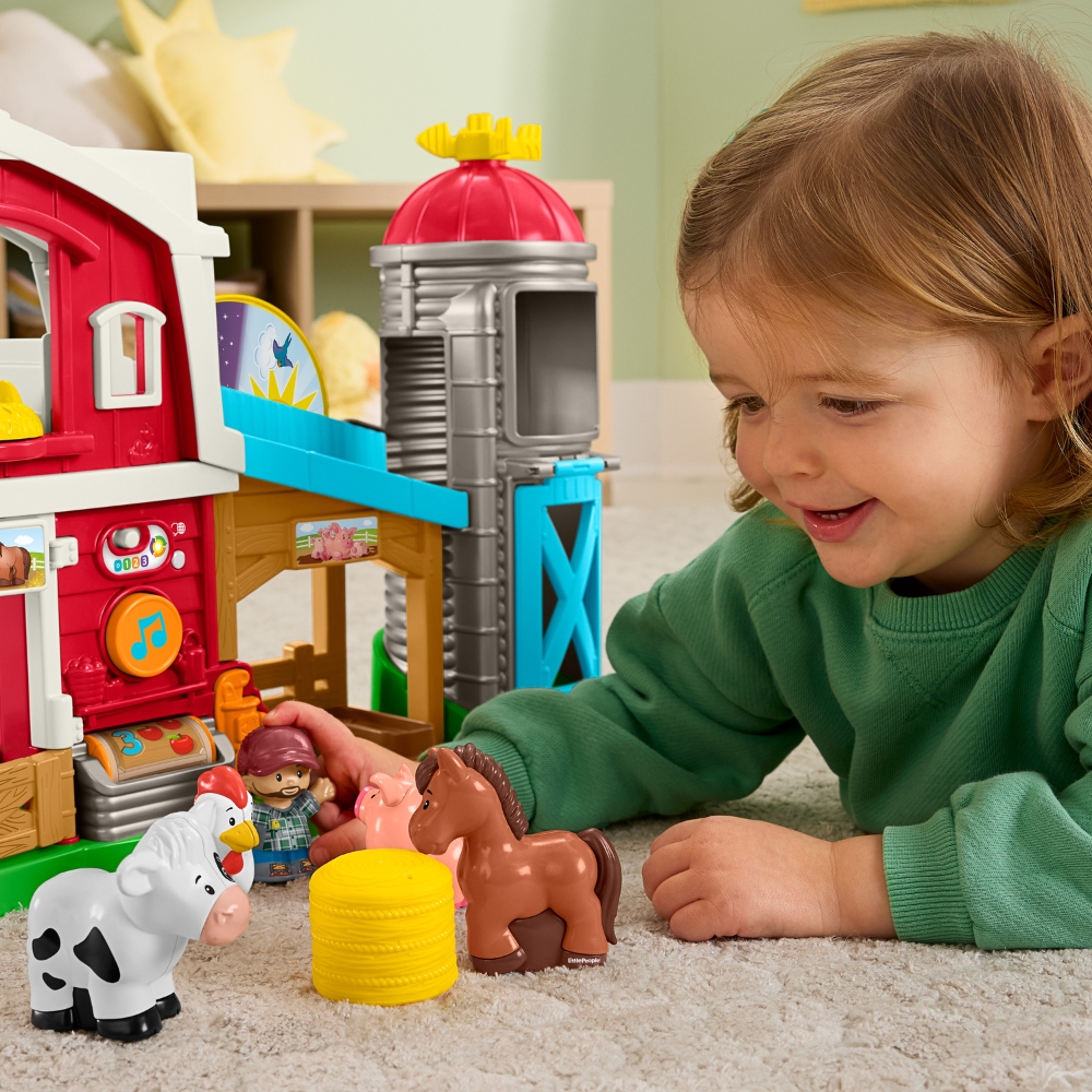 lapsi leikkimässä maatilalelulla